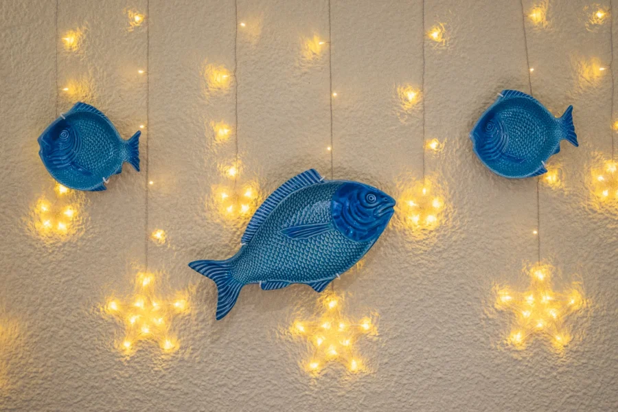 Peces azules de cerámica y luces en la pared de la sala de Lo de Sancho